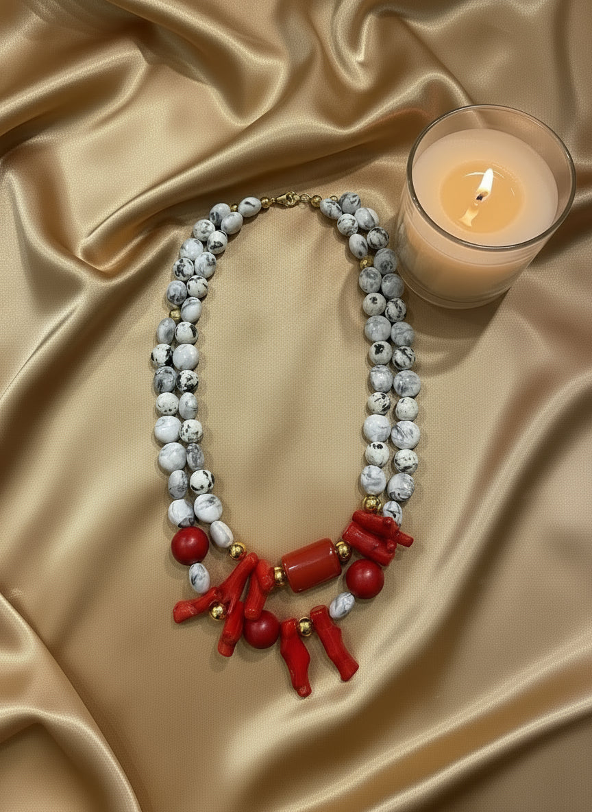 Jewelry set with red and white beads on a black mannequin bust.