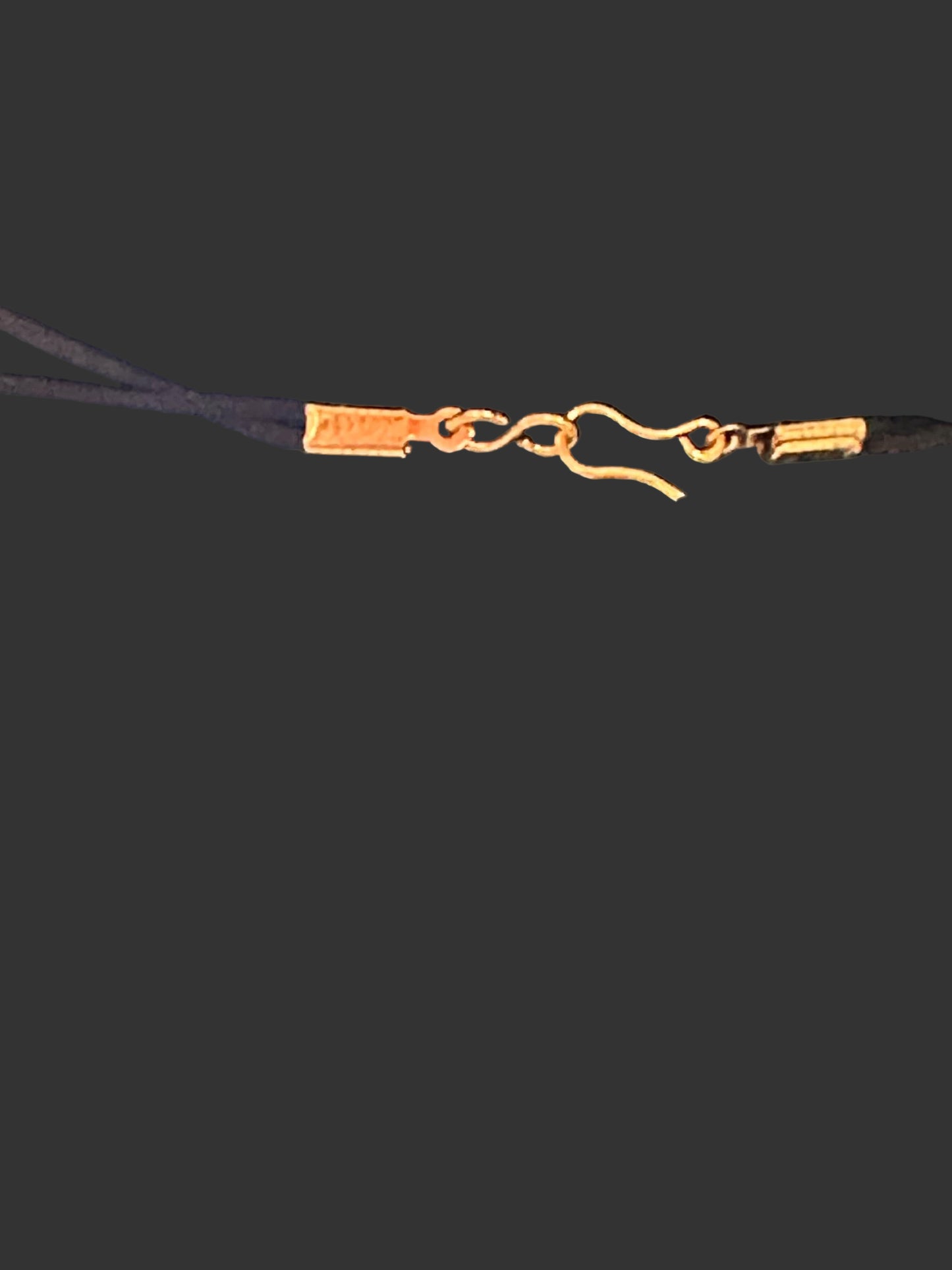 Gold earring on a dark fabric background