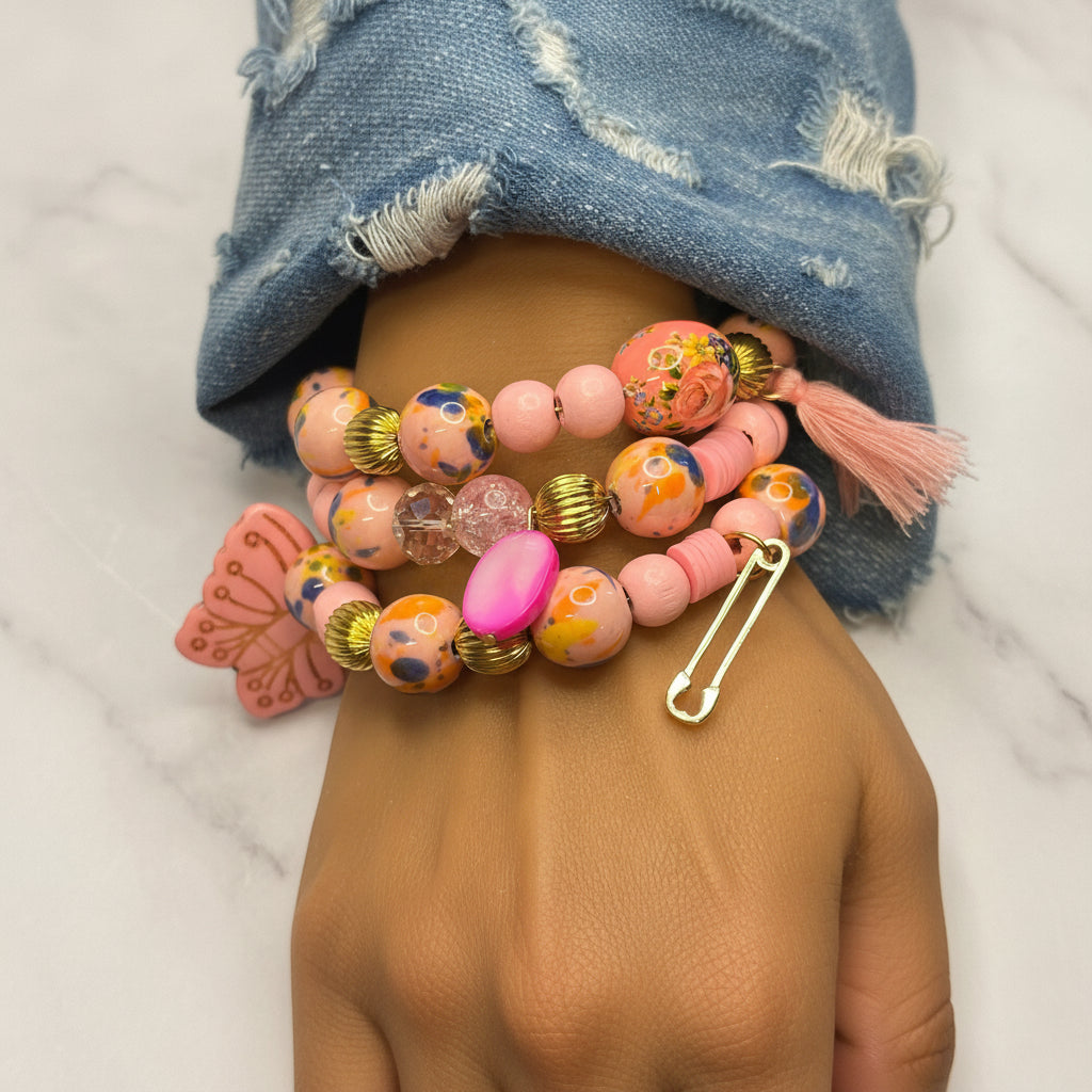 Colorful beaded bracelet with a safety pin on a person's wrist, wearing a denim jacket.