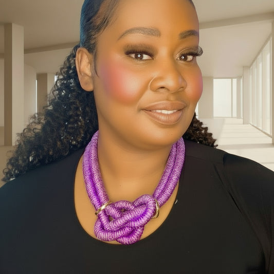 Woman wearing a purple knotted necklace against a white background